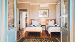 a bedroom with two beds with white sheets at Authentic Mossel Bay in Mossel Bay