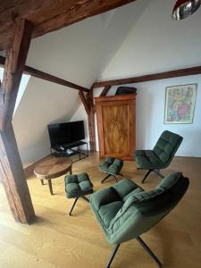 a living room with green chairs and a flat screen tv at Ferienhaus Ritter in Hard