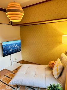 a bedroom with a large bed and a yellow wall at 海が見える隠れ家 -Tsukushi瀬戸内- in Takamatsu +81 photos