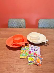 a table with plates and bowls and a napkin at 海が見える隠れ家 -Tsukushi瀬戸内- in Takamatsu