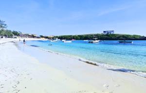 a sandy beach with boats in the water at Watamu Ascot Residence in Watamu