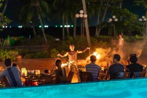 a man standing in front of a fire by a pool at The Happy Marina Hotel Phú Quốc - Sunset & Ocean View in Phú Quốc +79 photos