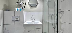 a white bathroom with a sink and a shower at Pokoje Syrenka by TriApart in Stegna +126 photos