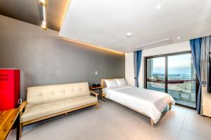 a bedroom with a bed and a couch and a window at Donnaekohill Resort in Seogwipo +91 photos