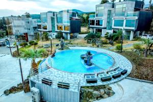 un complejo de apartamentos con una piscina con una fuente en Donnaekohill Resort en Seogwipo