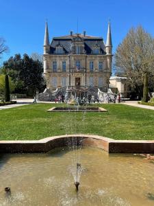 a fountain in the middle of a pond in front of a building at Appartement in Courthézon