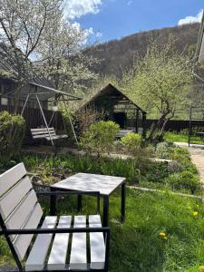 a bench and a table in a garden at Три горішки in Yaremche