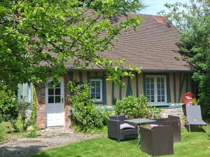 a house with a table and chairs in the yard at La Ferme aux Canards in Sassetot-le-Mauconduit +2 photos