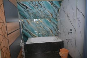 a bathroom with a sink and a marble wall at Alpine Vista Wellness & Resort in Gupta Kāshi