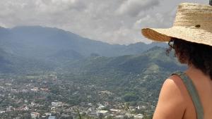a woman wearing a straw hat looking at a city at Ice mango homestay Badulla in Badulla