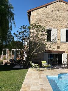 a house with two chairs and a swimming pool at Studio Clos des Renauds Borne Electrique in Charbonnières