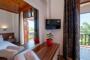 a bedroom with a bed and a tv and a window at Palma Rosa Hotel in Kemer