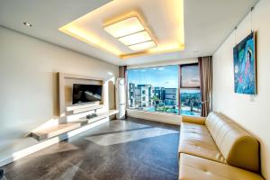 a living room with a couch and a large window at Donnaekohill Resort in Seogwipo