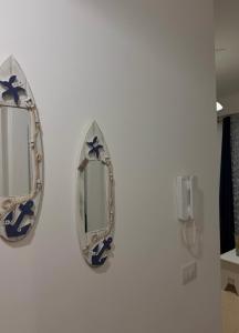 two mirrors on a wall in a bathroom at Ioanian Évasion in Vlorë +3 photos
