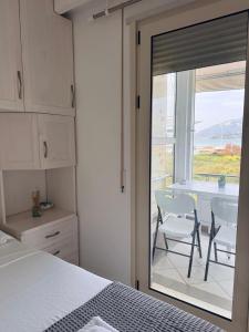 a bedroom with a bed and a table and a window at Ioanian Évasion in Vlorë