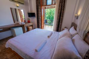 a bedroom with a bed with white sheets and a window at Palma Rosa Hotel in Kemer +28 photos