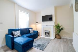 a blue couch in a living room with a fireplace at 3 Bedroom House in Rishton by Eason Stays, Great Location Near Shops & Transport in Rishton