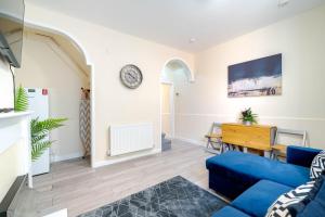 a living room with a blue couch and a table at 3 Bedroom House in Rishton by Eason Stays, Great Location Near Shops & Transport in Rishton