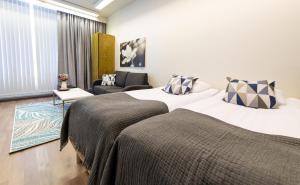 a hotel room with two beds and a couch at Hotelli Viikinhovi in Keuruu +91 photos