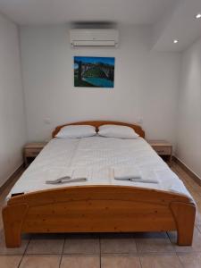ein Schlafzimmer mit einem Holzbett und weißen Laken in der Unterkunft Stanar in Grgar