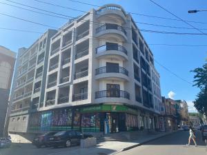 a large white building on the corner of a street at Home in Kutaisi