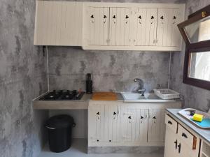 a kitchen with white cabinets and a sink at Villa Cayetana in Jávea