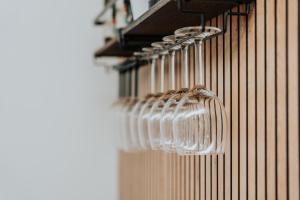 a row of wine glasses hanging on a wall at Saffi Suites in Noto