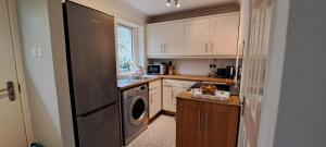 a kitchen with a stainless steel refrigerator and a dishwasher at Seaview Cottage, Drimnin in Drimnin
