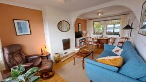 a living room with a blue couch and a table at Seaview Cottage, Drimnin in Drimnin