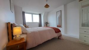 a bedroom with a bed with a lamp and a window at Seaview Cottage, Drimnin in Drimnin