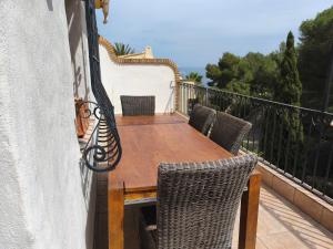 a balcony with a wooden table and chairs at Villa Cayetana in Jávea