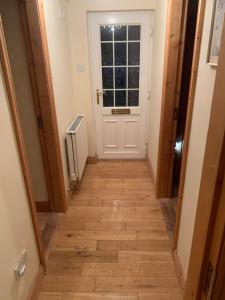 a hallway with a white door and a window at Stickens Apartment in Naas