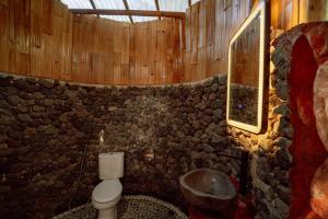a stone bathroom with a toilet and a sink at Bambu Teras Viewpoint in Karangasem