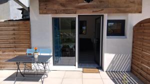 a patio with a table and chairs in front of a house at Chez Sophie, au calme, climatisé, proche d'Aix-les-bains in Grésy-sur-Aix