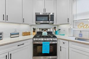a kitchen with a stove and a microwave at Cozy Shoregri La! - Beach block! in Seaside Heights