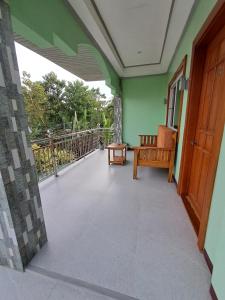a balcony with a wooden door and a chair at JMM Guest House in Panglao Island