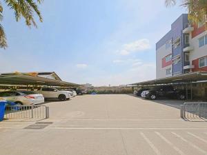 a parking lot with cars parked in front of a building at H-Hub BBT in Ban Khlong Yuan