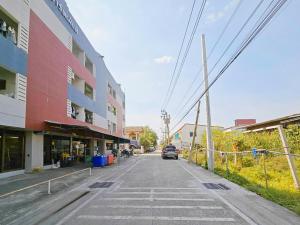 an empty street with a car driving down the street at H-Hub BBT in Ban Khlong Yuan