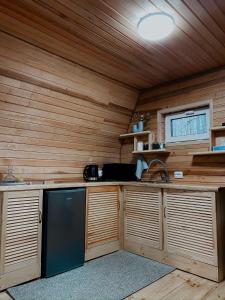 a kitchen with wooden cabinets and a sink in a room at A-frame будиночок in Staraya Guta