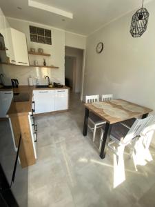 a kitchen with a wooden table and a dining room at Apartament DeLux WHITE Konin in Konin +3 photos