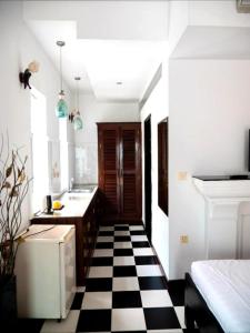 eine Küche mit schwarz-weiß kariertem Boden in der Unterkunft Saba Lua Siem Reap in Siem Reap