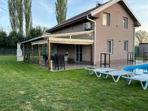 a house with a patio with tables and a pool at Villa Gjorgjevikj in Kumanovo