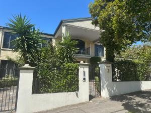 a white fence in front of a house at Shine House in Balwyn North