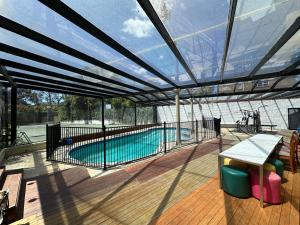 a swimming pool inside of a building with a glass ceiling at Shine House in Balwyn North