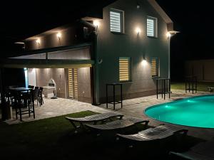 a house with a swimming pool at night at Villa Gjorgjevikj in Kumanovo
