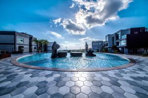 uma grande piscina de água com uma estátua no meio em Donnaekohill Resort em Seogwipo