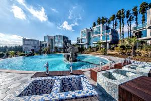 a swimming pool with a fountain in a resort at Donnaekohill Resort in Seogwipo