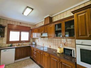 a large kitchen with wooden cabinets and a sink at Urmi 8 Vista Mar in Peniscola