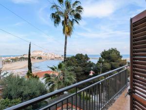 a balcony with a view of the beach and palm trees at Urmi 8 Vista Mar in Peniscola