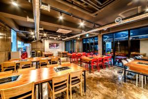 a dining room with wooden tables and red chairs at Donnaekohill Resort in Seogwipo